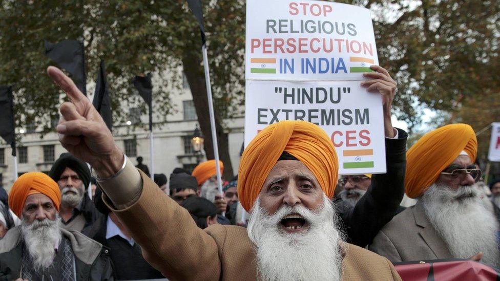 People at a protest held when Narendra Modi visited the UK. One placard says "stop religious persecution in India"