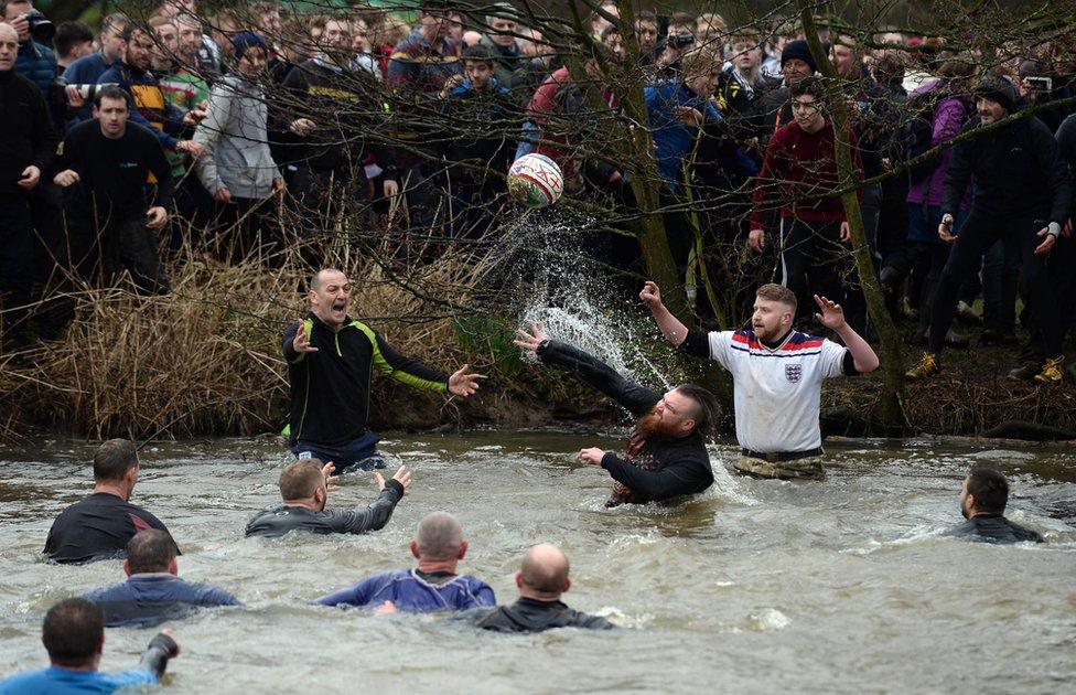 Players in a river during the 2017 Royal Shrovetide Football match in Ashbourne, Derbyshire