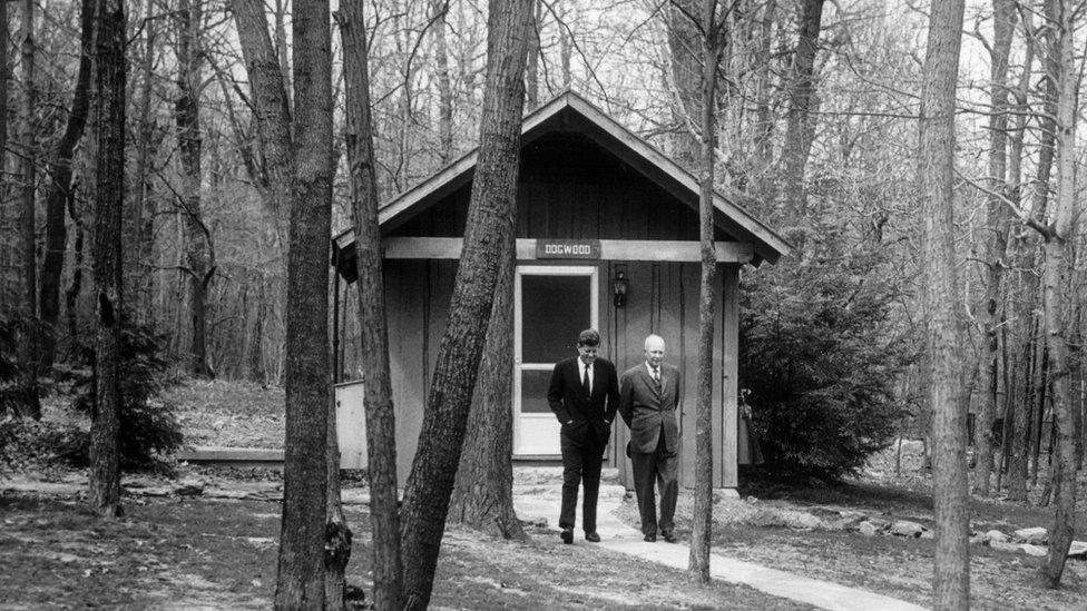 JFK and Eisenhower walking in Camp David.