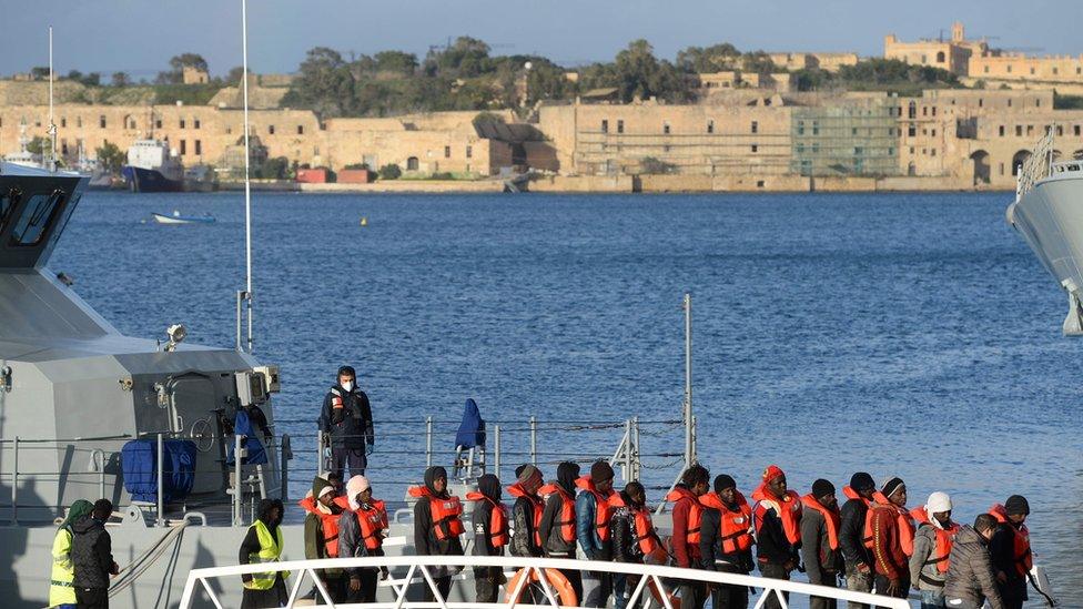 Migrants disembark from a Maltese coastal patrol boat