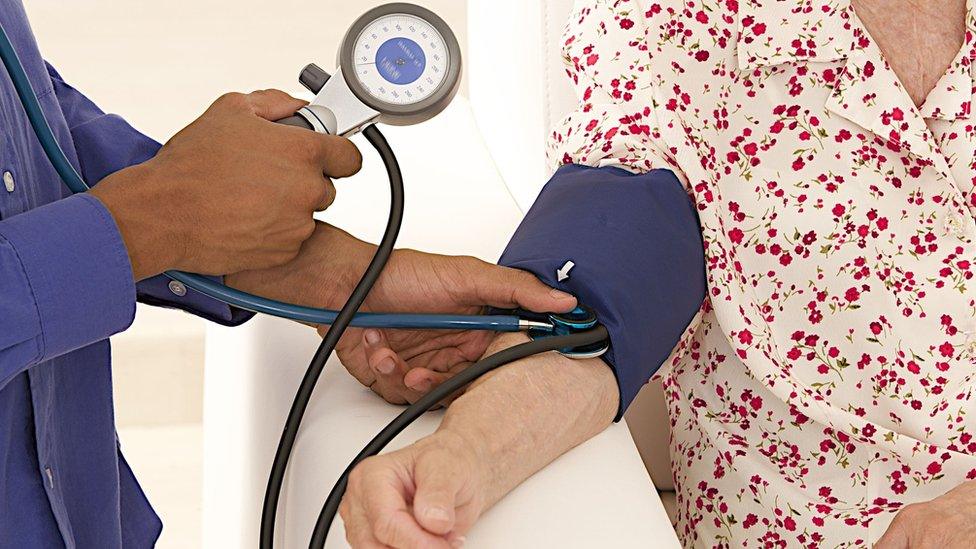 Elderly woman having blood pressure tested