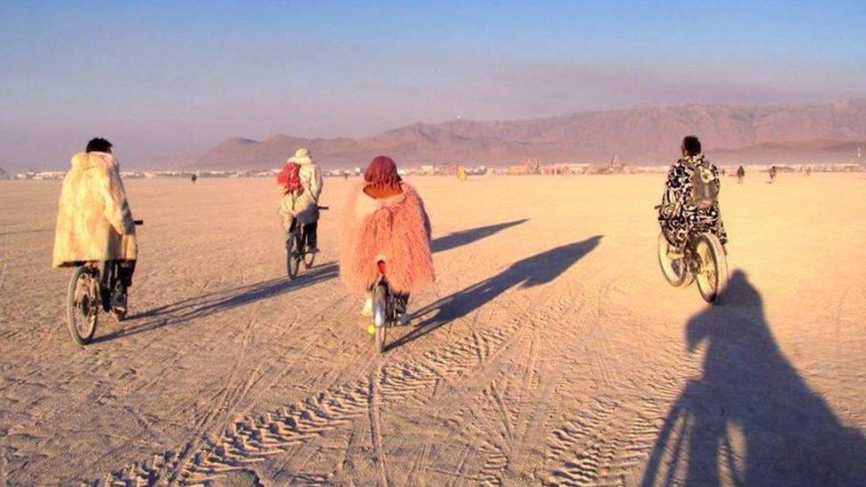 Four people riding bikes at Burning Man