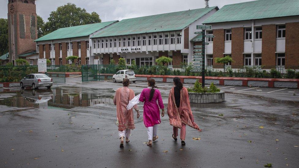 Women walk towards a school in Srinagar