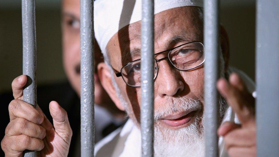 Muslim cleric Abu Bakar Ba'asyir is seen behind bars before his hearing verdict at the South Jakarta District Court on June 16, 2011