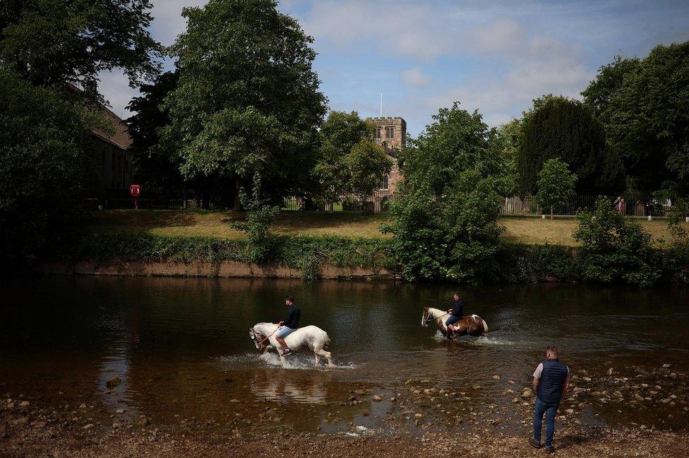 Members of the traveller community wash their horses in the River Eden during the annual horse fair in Appleby