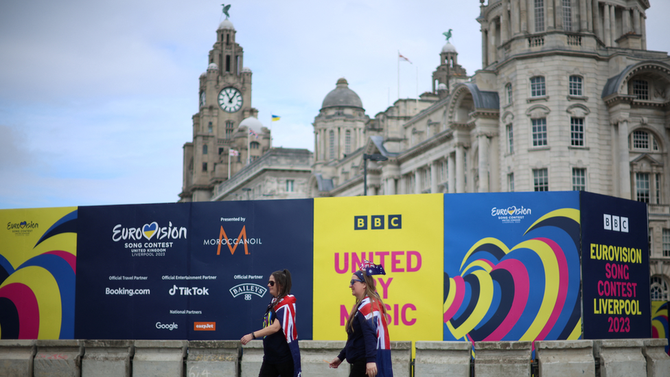 Eurovision fans wearing Australian flags, walk near the fanzone