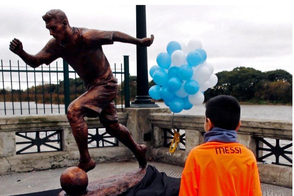 A boy wears a Lionel Messi jersey as he approaches the statue of Argentina's soccer player Messi after it was unveiled in Buenos Aires, Argentina, June 28, 2016.