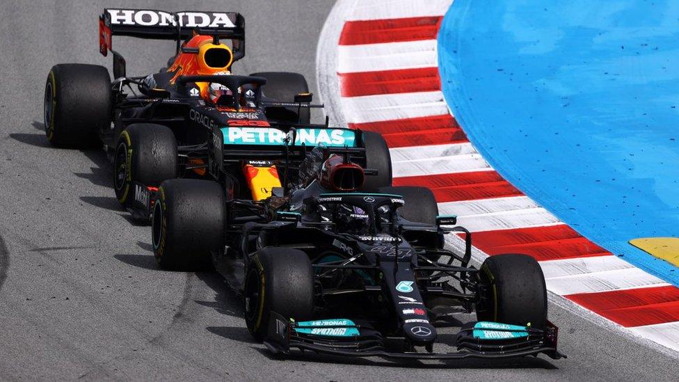 Max Verstappen and Lewis Hamilton battling on track