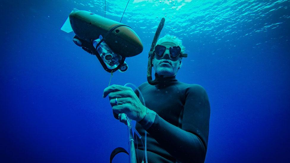 Presenter under water with a tow-cam