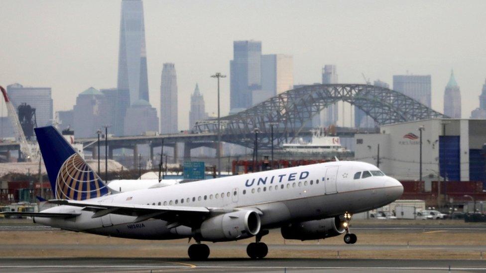 A United Airlines passenger jet takes off with New York City as a backdrop