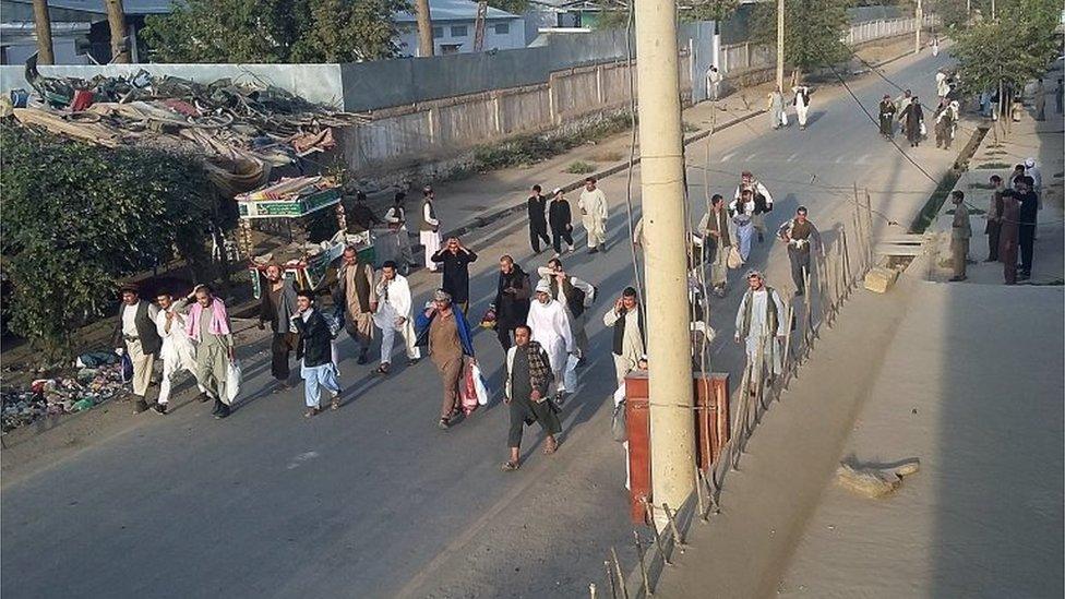 Taliban prisoners walk on a street after their comrades released them from the main jail in Kunduz, north of Kabul, Afghanistan (28 Sept 2015)