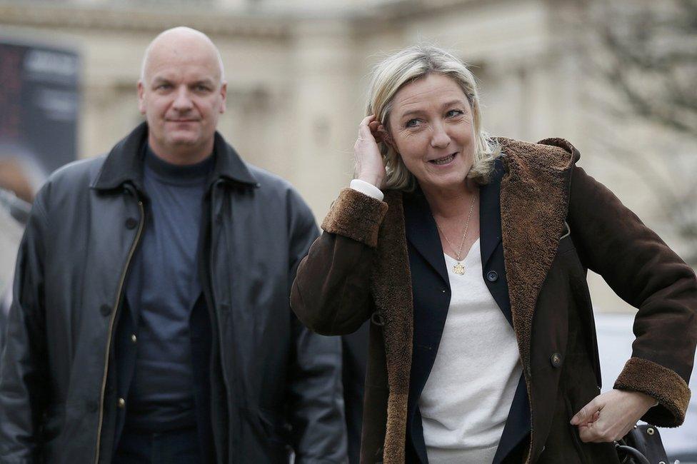 Marine Le Pen arrives with her bodyguard Thierry Legier (L) to visit the Christmas market on the Champs Elysees in Paris, France, 22 December 2014