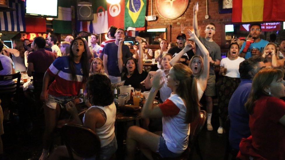 Gaites Layton, right with her hands up, watching the game