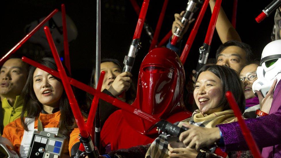 Chinese Star Wars fans hold light sabers during an event at the Great Wall of China