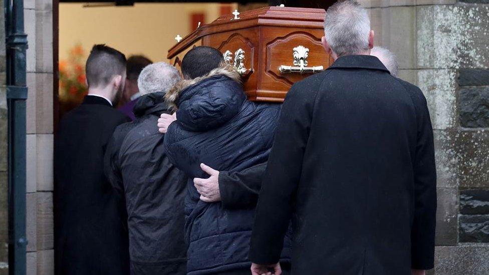 Mourners carrying the coffin into the church