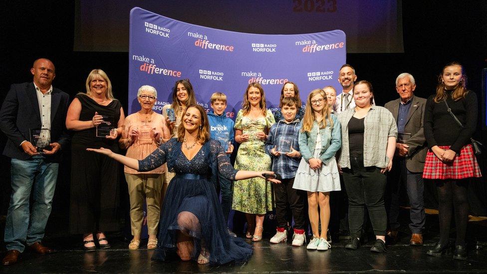 A group of award winners standing on a stage