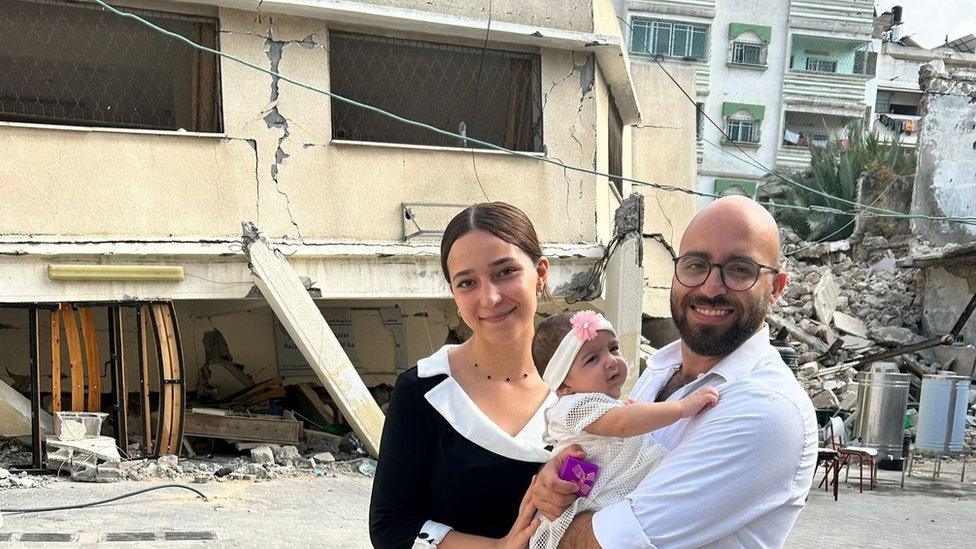 Marian and her husband and daughter on the day of her daughter's Baptism, outside the St Porphyrius Church building the was destroyed