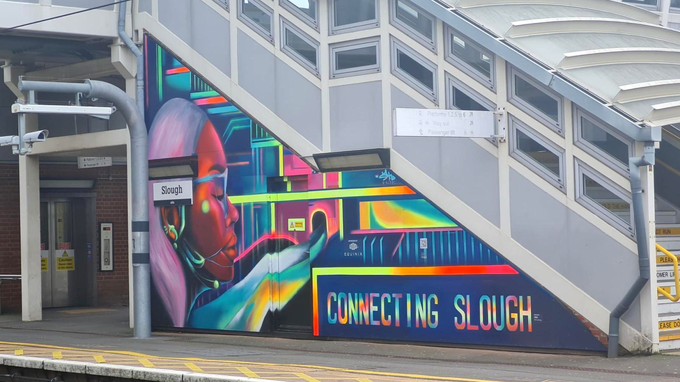 Colourful mural at station that reads "connecting Slough"