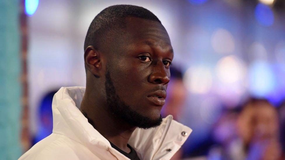 Stormzy in a white coat