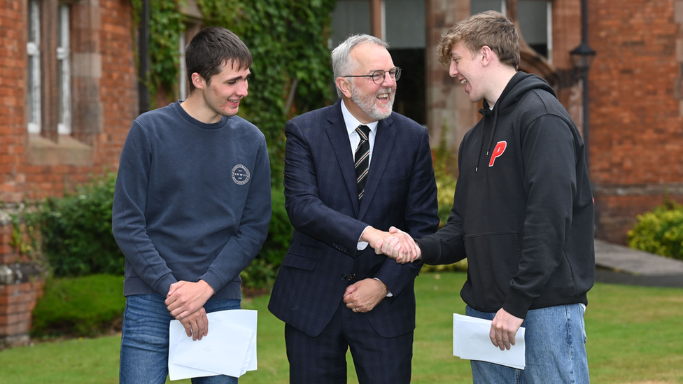 Campbell College principal Robert Robinson congratulates Patrick Kenny who was awarded four A*/A and (right) Tom Crowther who was awarded three As in their A-levels