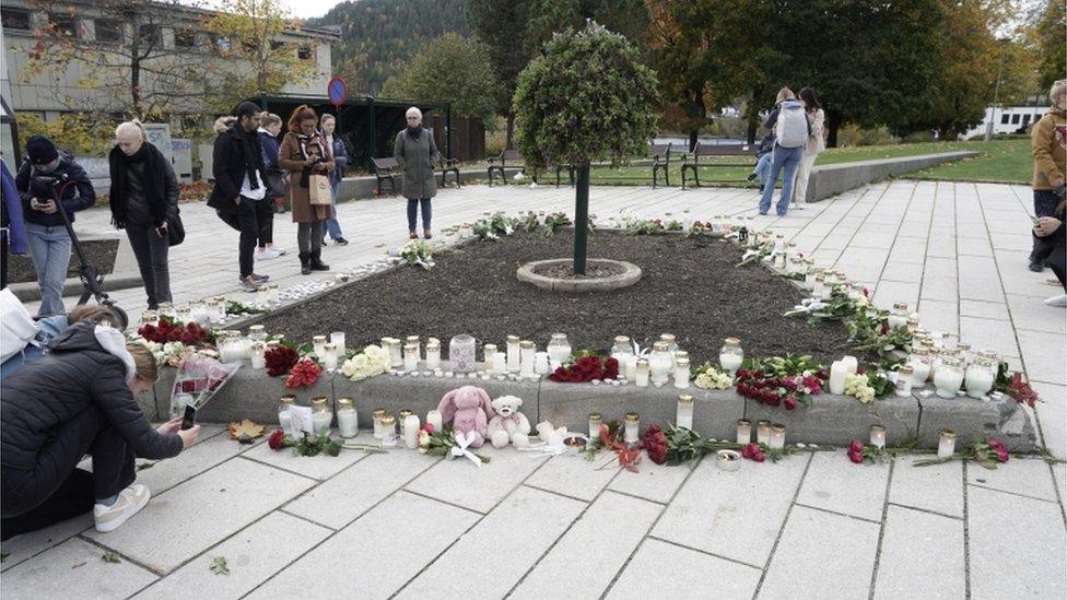 People in Kongsberg place tributes for the dead after an attack which left five people dead in the town