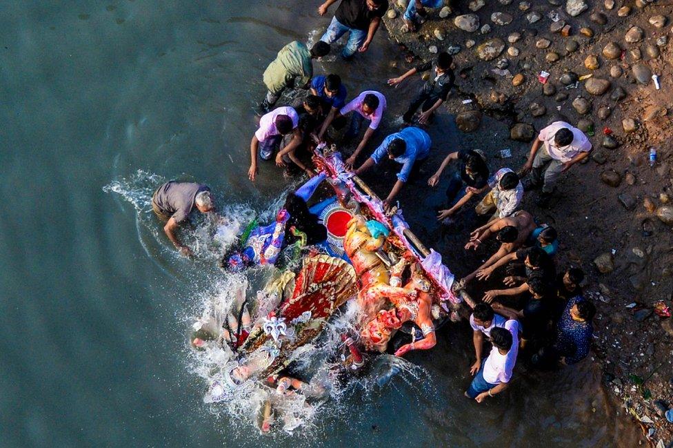 Hindu devotees submerge a clay idol of the Hindu goddess Durga on the final day of the Durga Puja festival in Dhaka on 8 October 2018.