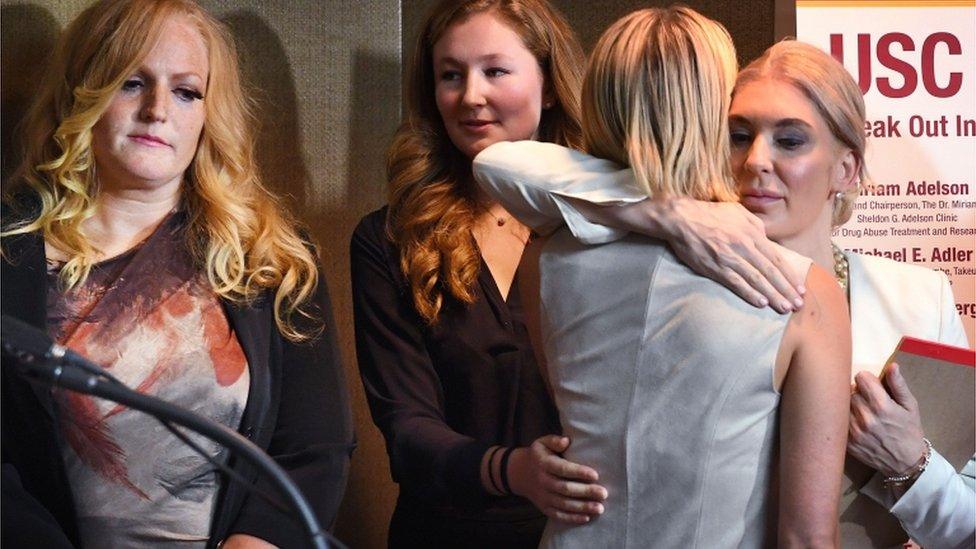 Survivors hug during news conference