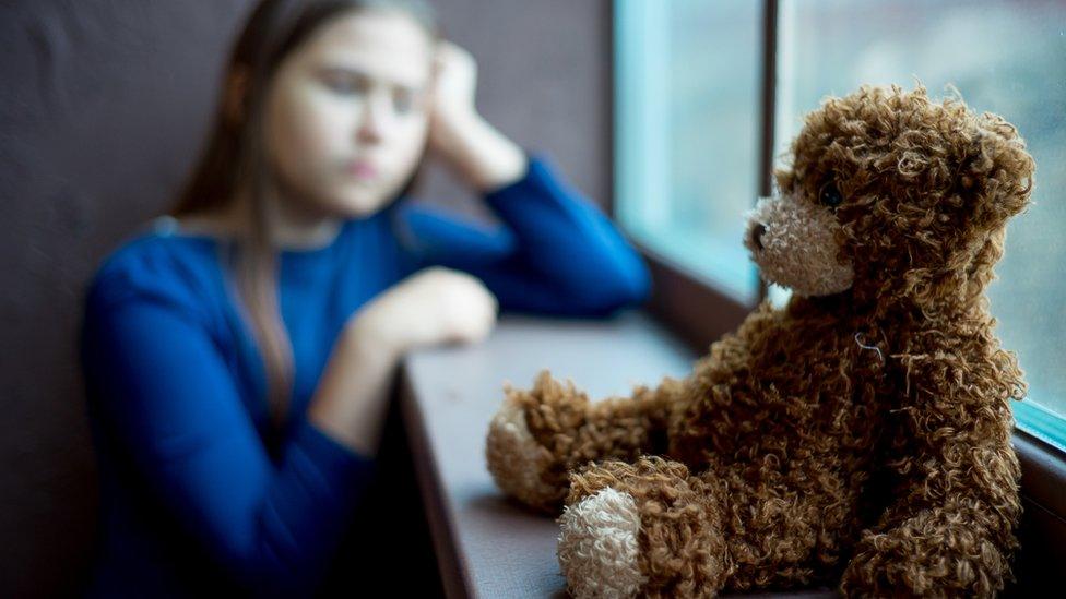 A child and her teddy bear