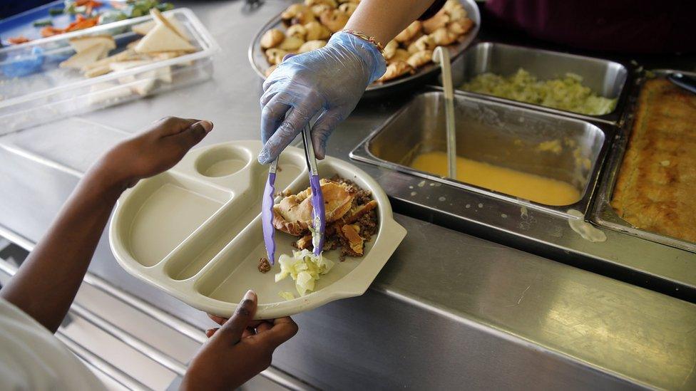 Photo from 2014 showing a young pupil being served a hot school meal at Salusbury Primary School in north-west London.