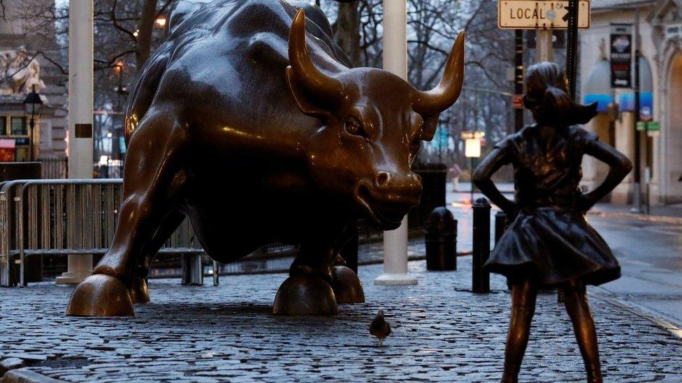 A statue of a girl facing the Wall St. Bull is seen, as part of a campaign by a US fund manager State Street to push companies to put women on their boards, in the financial district in New York