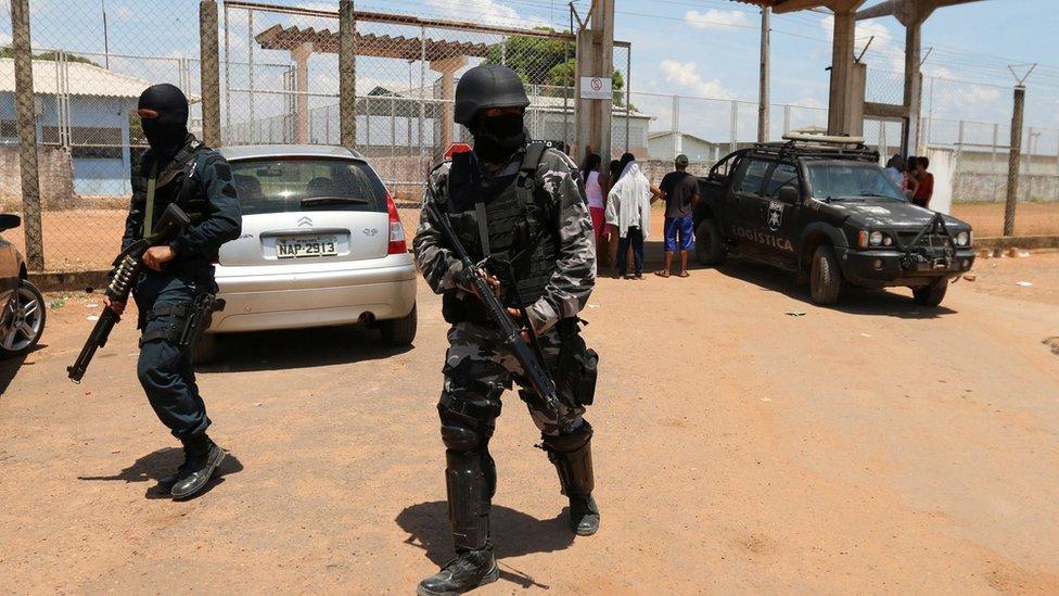 Riot police officers patrol outside a prison after clashes between rival criminal factions in Boa Vista, Brazil