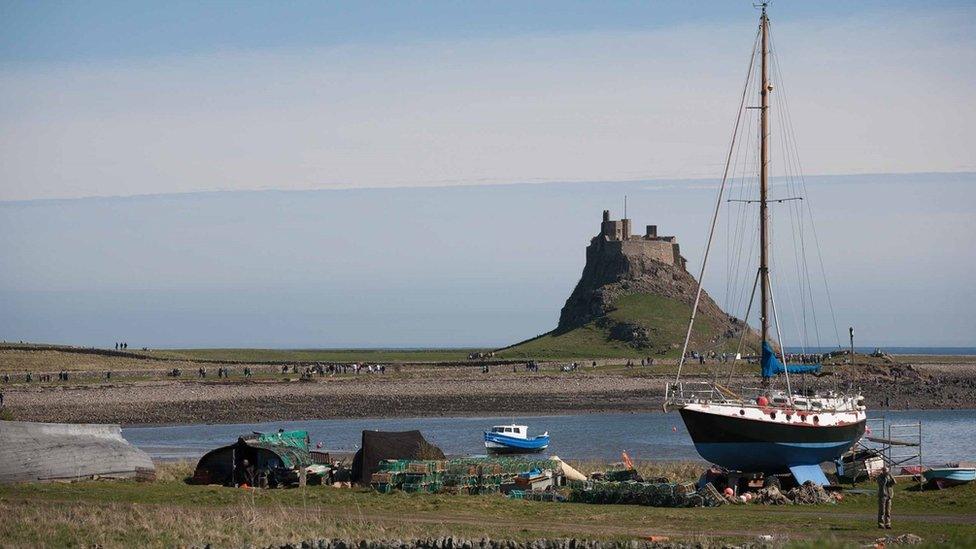 A view of Lindisfarne Castle in the distance across The Ouse