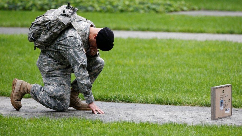 A soldier honours a victim at the memorial in New York City