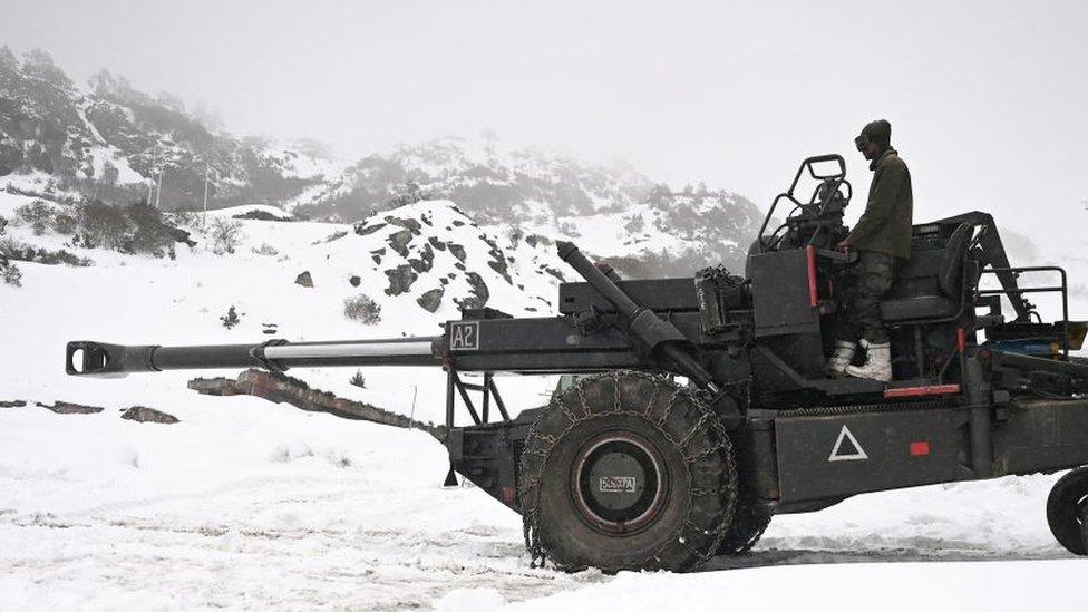 This picture taken on April 3, 2023 shows an Indian army soldier on a Bofors gun at a camp near Pankang Teng Tso Lake in the Tawang district of India's Arunachal Pradesh state. - Freshly laid roads, bridges, upgraded military camps, and new civilian infrastructure dot the winding high Himalayan route to the Indian frontier village of Zemithang -- which China renamed last month to press its claim to the area. It is in the far northeastern Indian state of Arunachal Pradesh, almost all of which Beijing insists falls under its sovereignty as "South Tibet"