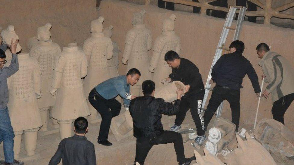 Police dismantling the fake statues