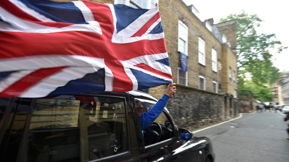 Black taxi driver waves Union Jack