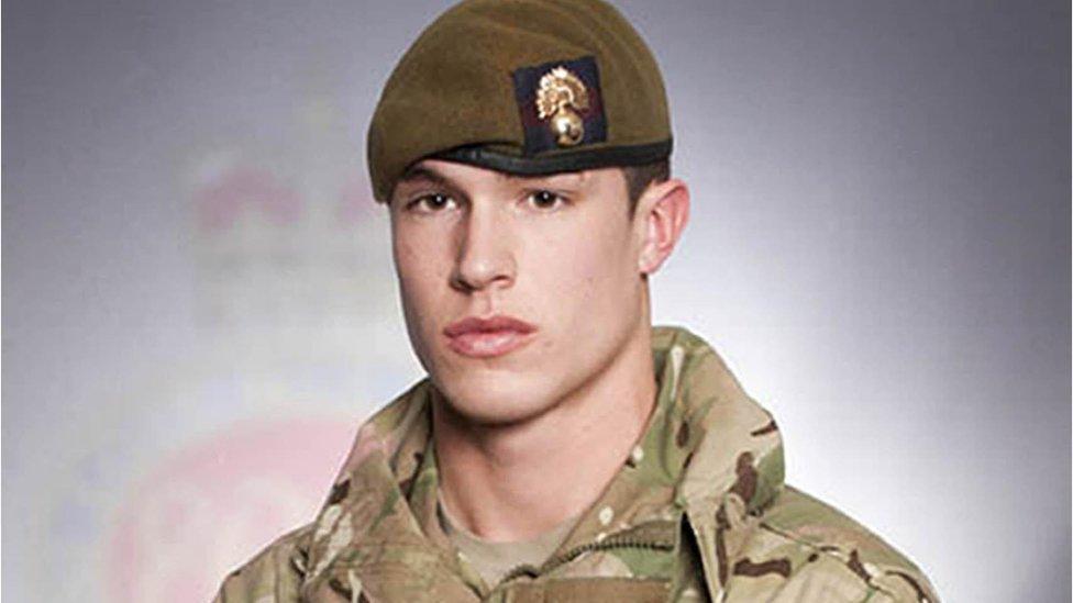 Young man with short dark hair under a beret in army camouflage uniform