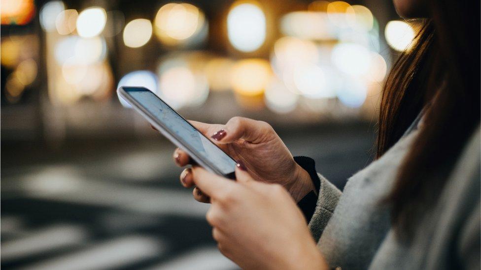 A woman holding a phone