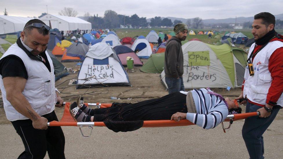 Medical volunteers carry a woman on a stretcher after she collapsed at the Idomeni camp (07 March 2016)