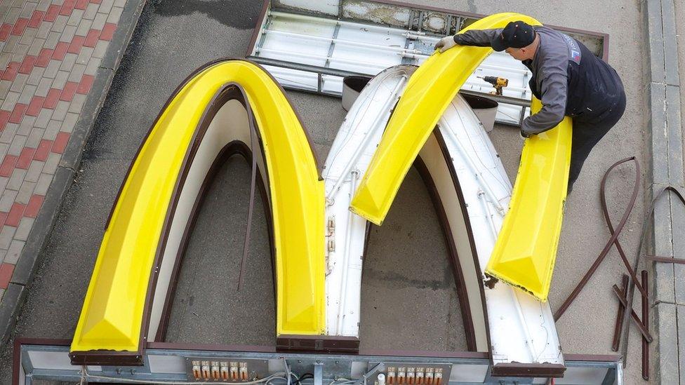 A worker removing a McDonald's sign in Russia.