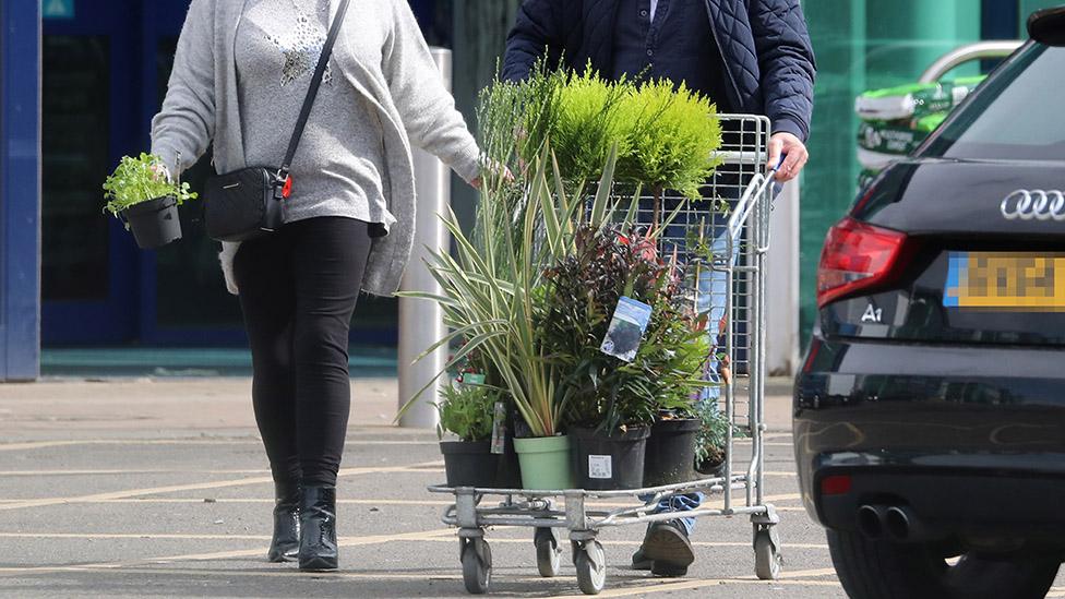 Shoppers with a trolley of plants