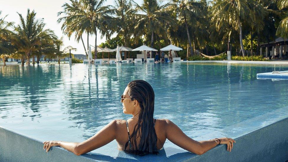 A woman relaxing in a swimming pool at a resort