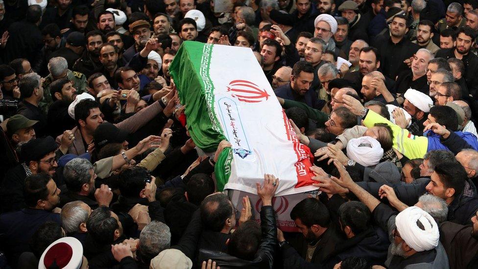 Iranian people carry the coffin of Qasem Soleimani during a funeral procession in Tehran, 6 January 2020