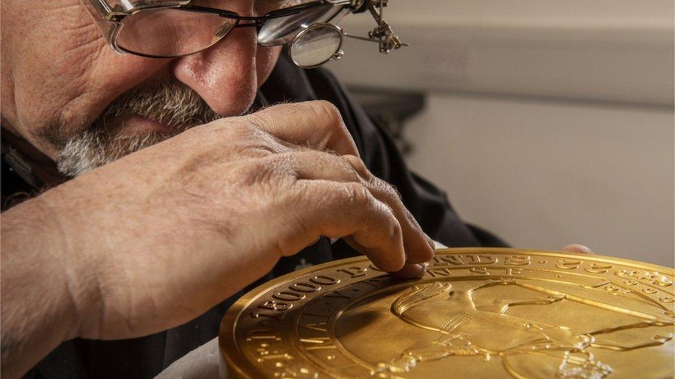 Man studies the coin.