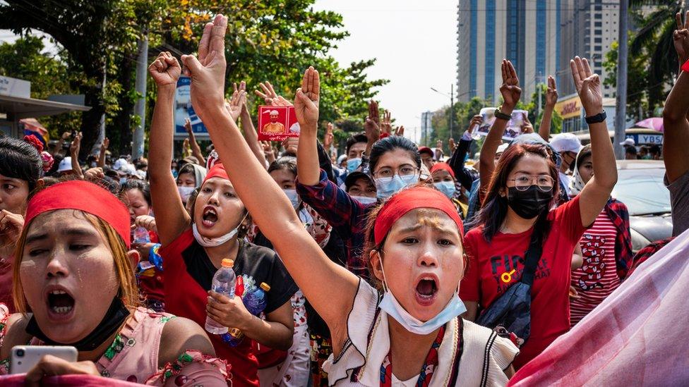 People make three-finger salutes during an anti-coup march in Yangon, Myanmar