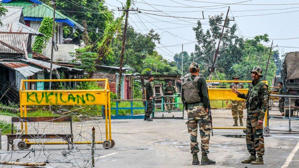 Security forces guard a road to a village in the north-eastern state of Manipur