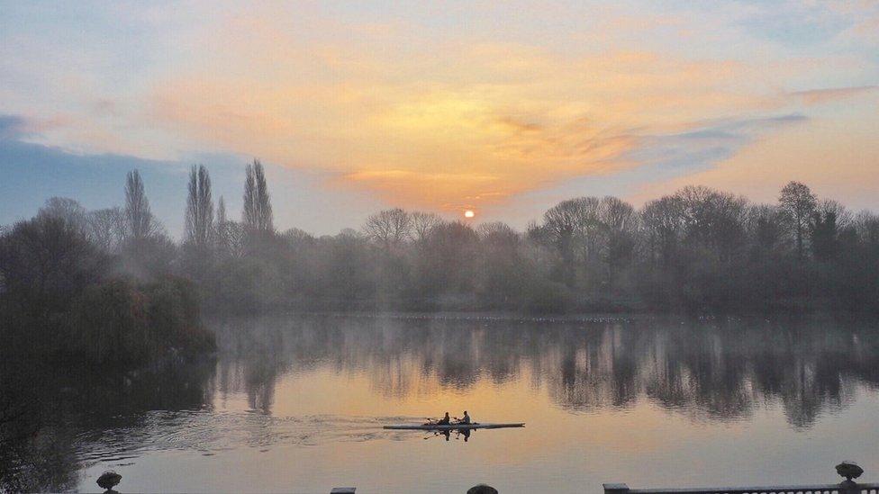 Rowers on a lake in Twickenham as the sun rises