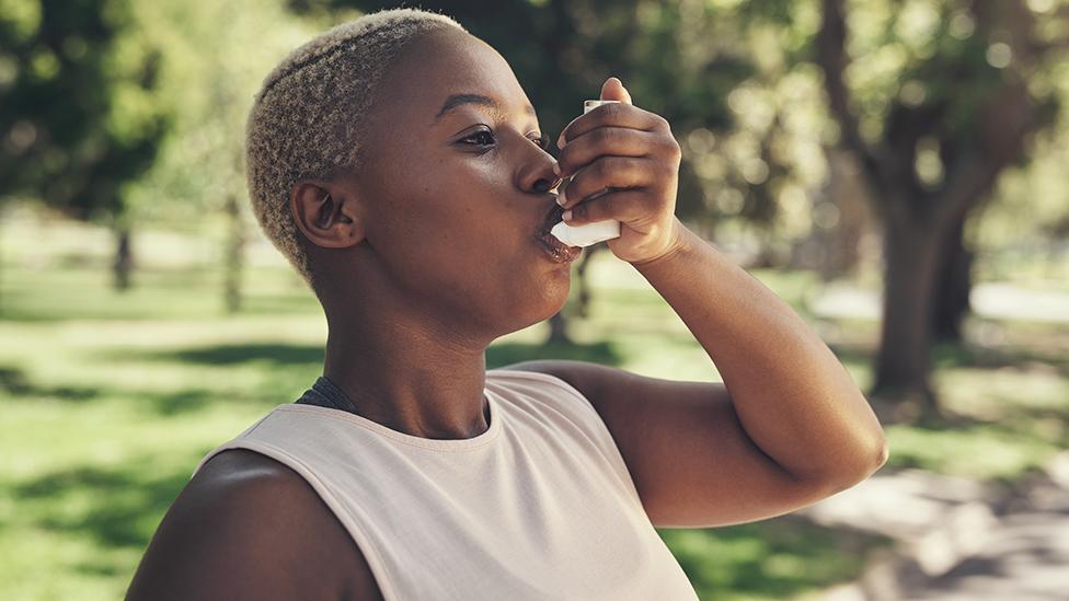 A woman using an asthma inhaler