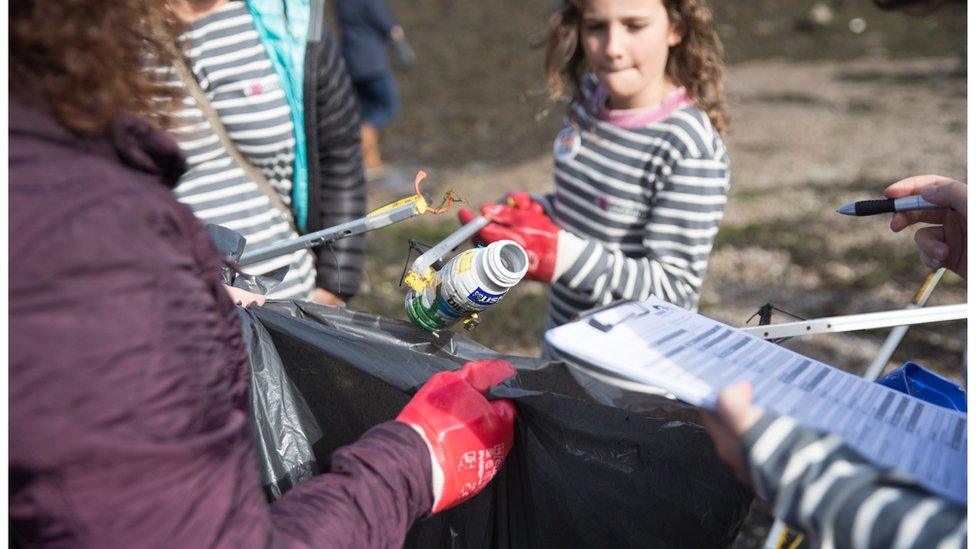 Volunteers litter pick waste from the coastline