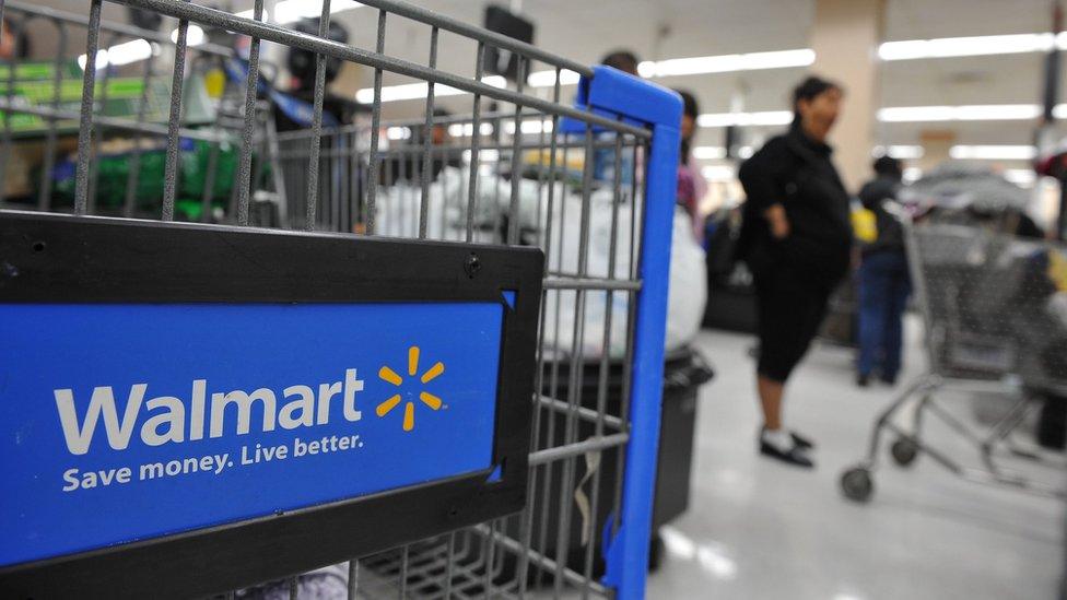 Shoppers wait in line to pay for their purchases at a Walmart store in Los Angeles, California on November 24, 2009,